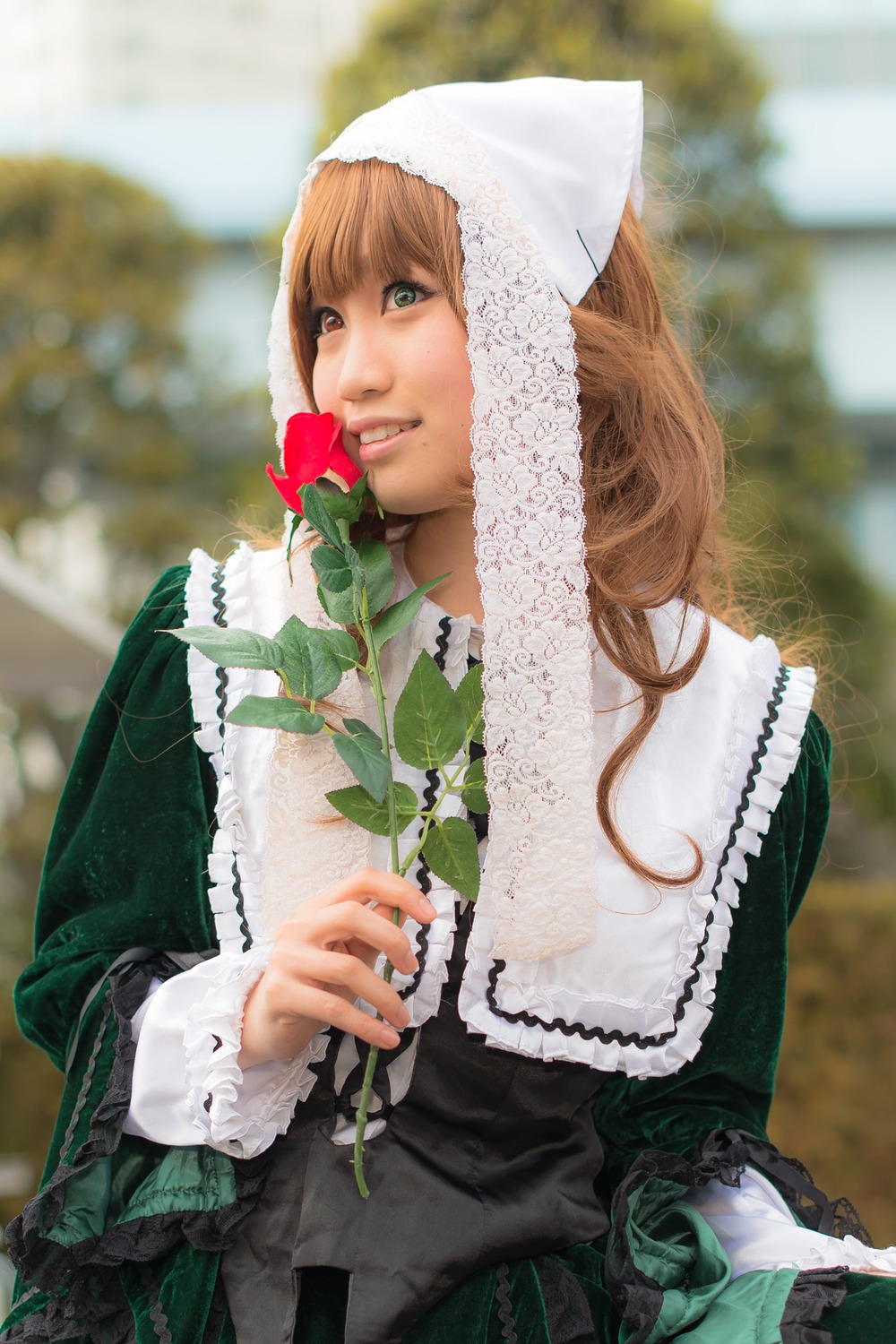 1girl blurry blurry_background brown_hair depth_of_field dress frills green_dress green_eyes heart lace lolita_fashion long_hair long_sleeves outdoors photo realistic solo suiseiseki