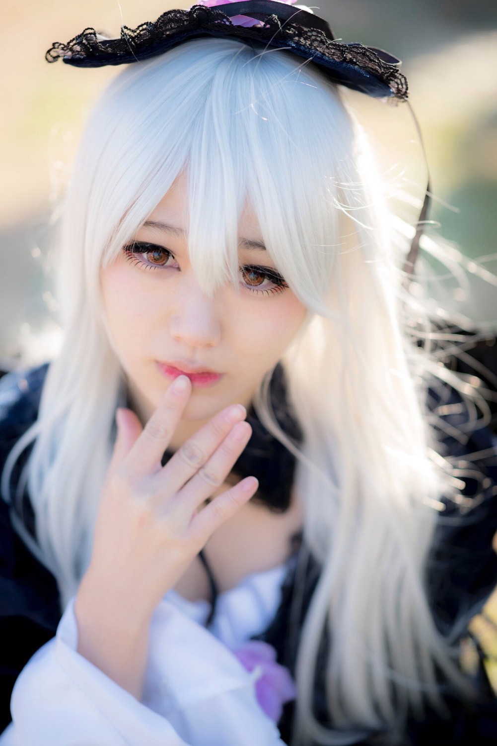 1girl blurry blurry_background blurry_foreground brown_eyes depth_of_field hair_between_eyes long_hair long_sleeves looking_at_viewer solo suigintou white_hair