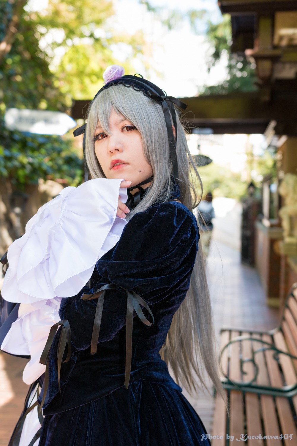 1girl black_dress blurry blurry_background blurry_foreground depth_of_field dress flower hairband lips parted_lips photo solo suigintou