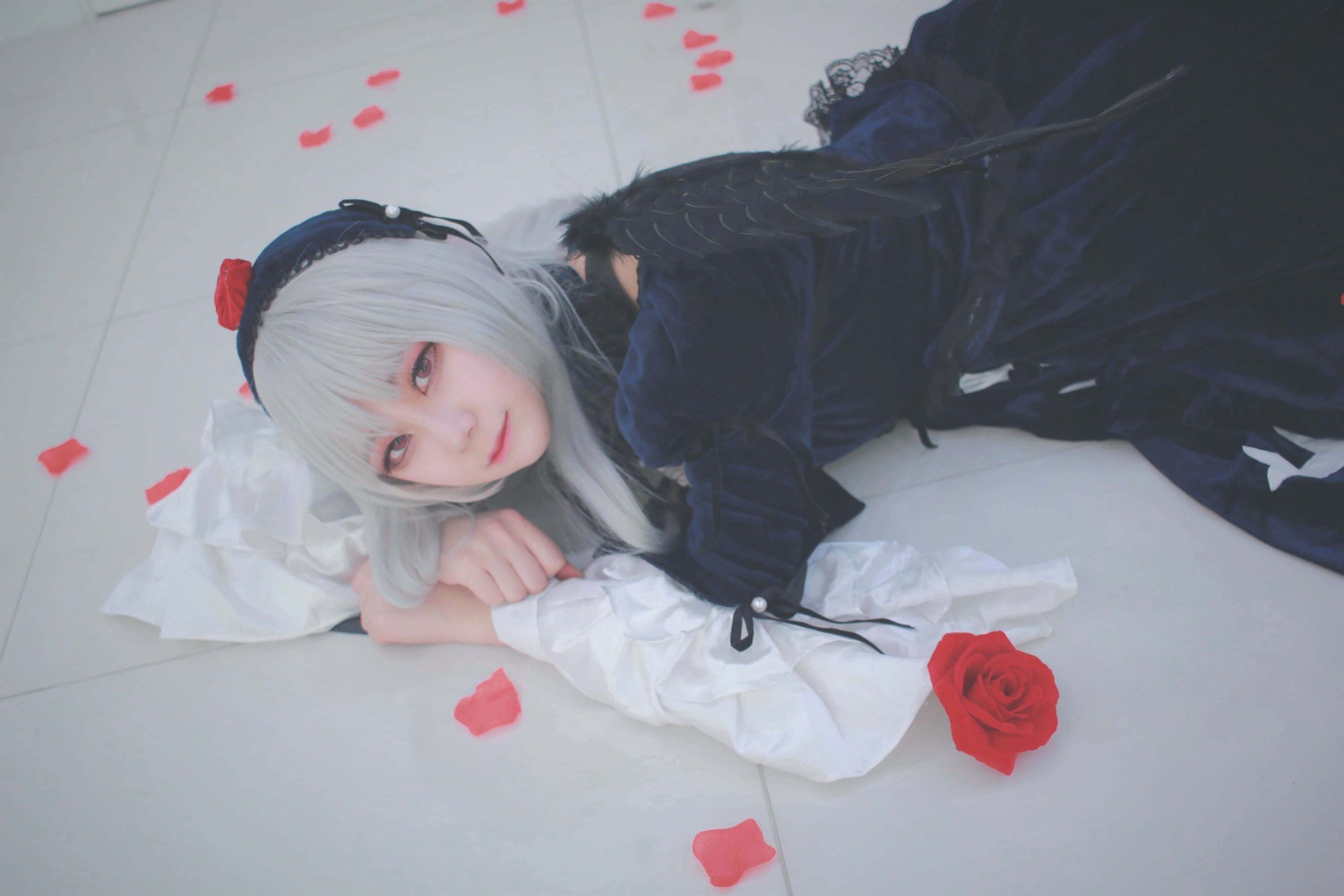 1girl black_dress closed_mouth dress flower gothic_lolita hairband lips lolita_fashion long_sleeves looking_at_viewer lying on_side petals red_flower red_rose rose rose_petals solo suigintou