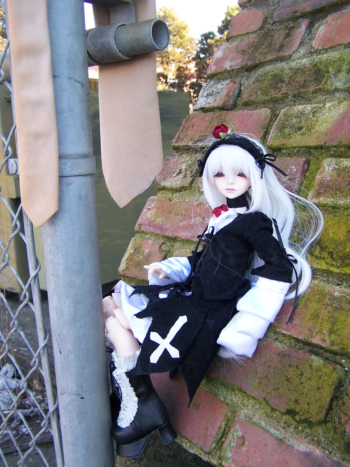 1girl black_dress black_footwear boots closed_eyes doll dress flower hairband long_hair outdoors rose sitting solo suigintou white_hair