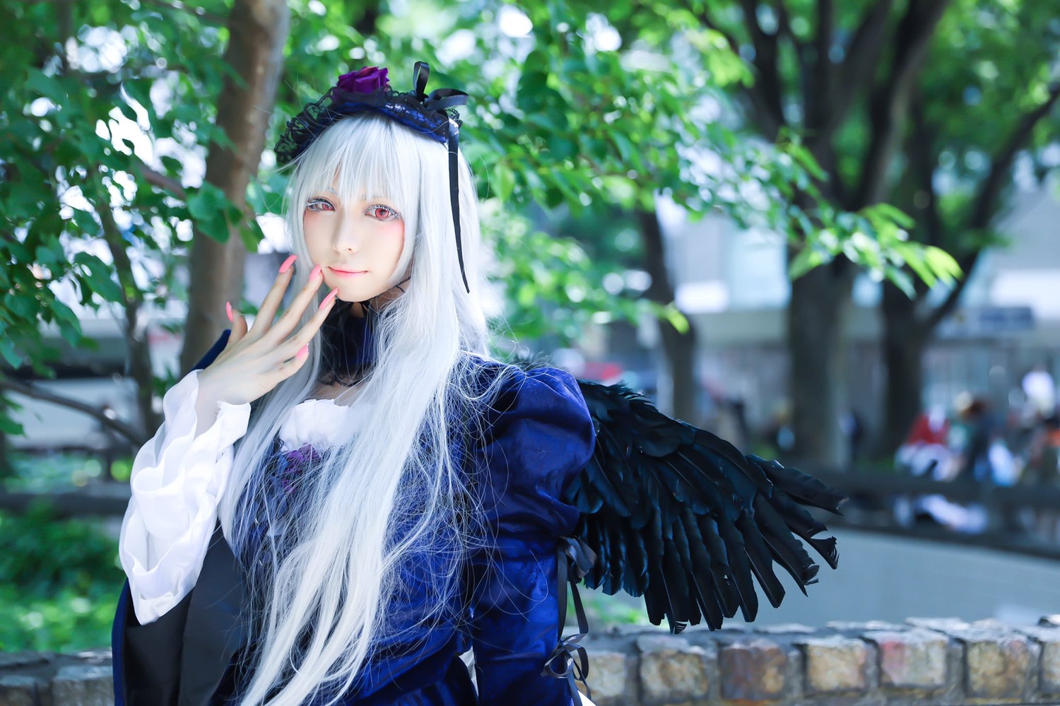 1girl bangs black_wings blurry blurry_background blurry_foreground closed_mouth depth_of_field dress feathered_wings long_hair long_sleeves looking_at_viewer nail_polish outdoors red_eyes smile solo suigintou white_hair wings