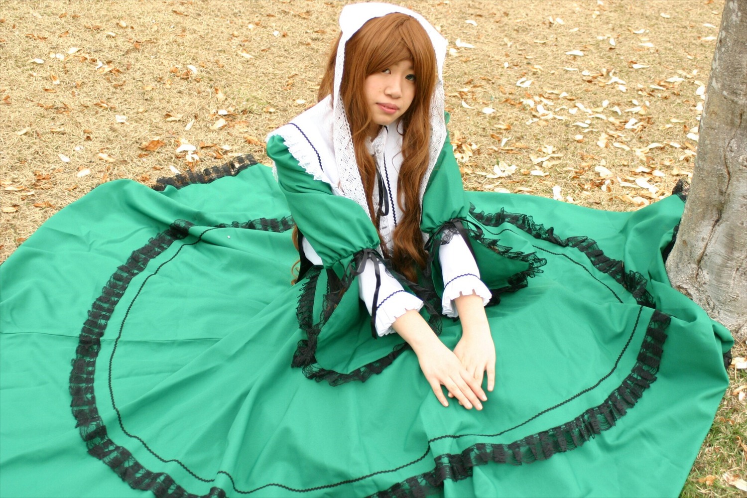 1girl brown_hair dress frills green_dress long_hair long_sleeves own_hands_together sitting solo suiseiseki