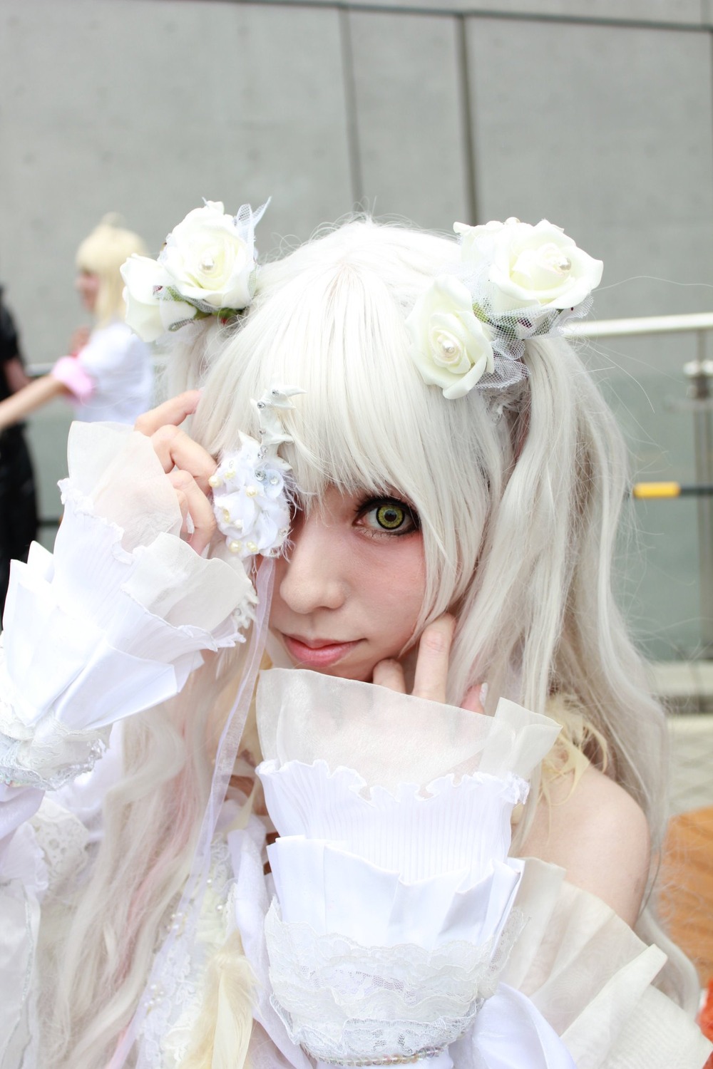 1girl bangs bare_shoulders blurry blurry_background blurry_foreground closed_mouth depth_of_field dress flower green_eyes hair_ornament kirakishou lips long_hair looking_at_viewer photo solo upper_body white_flower white_hair white_rose