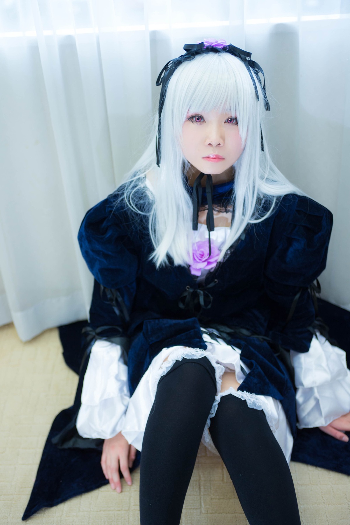 1girl bangs black_legwear blurry dress expressionless frills gothic_lolita hairband lips lolita_fashion long_hair long_sleeves looking_at_viewer puffy_sleeves sitting solo suigintou thighhighs