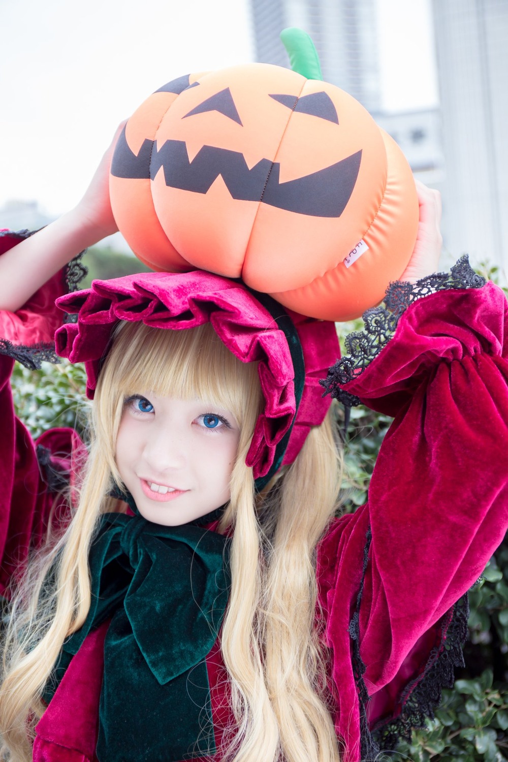 1girl bangs blonde_hair blue_eyes blurry bonnet hat jack-o'-lantern lips long_hair looking_at_viewer outdoors pumpkin shinku smile solo