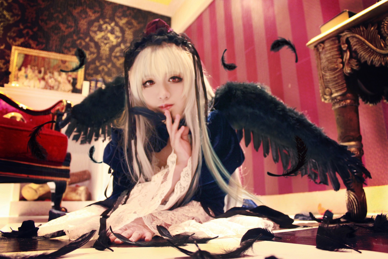 1girl bird black_wings blonde_hair crow dress feathers finger_to_mouth long_hair red_eyes solo suigintou wings