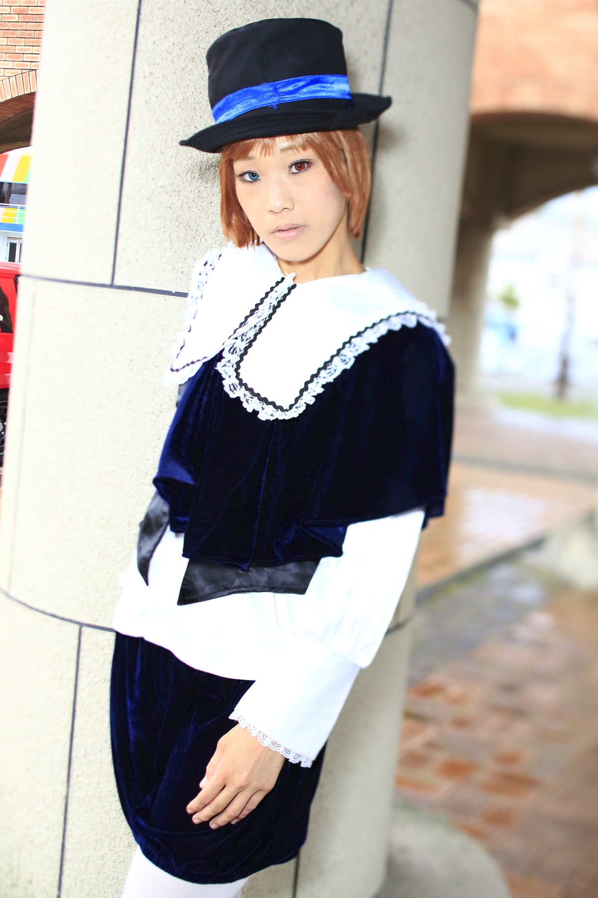 1girl 3d blue_eyes blurry blurry_background blurry_foreground brown_hair depth_of_field hat lips long_sleeves looking_at_viewer outdoors photo photo_background short_hair sitting solo souseiseki white_neckwear