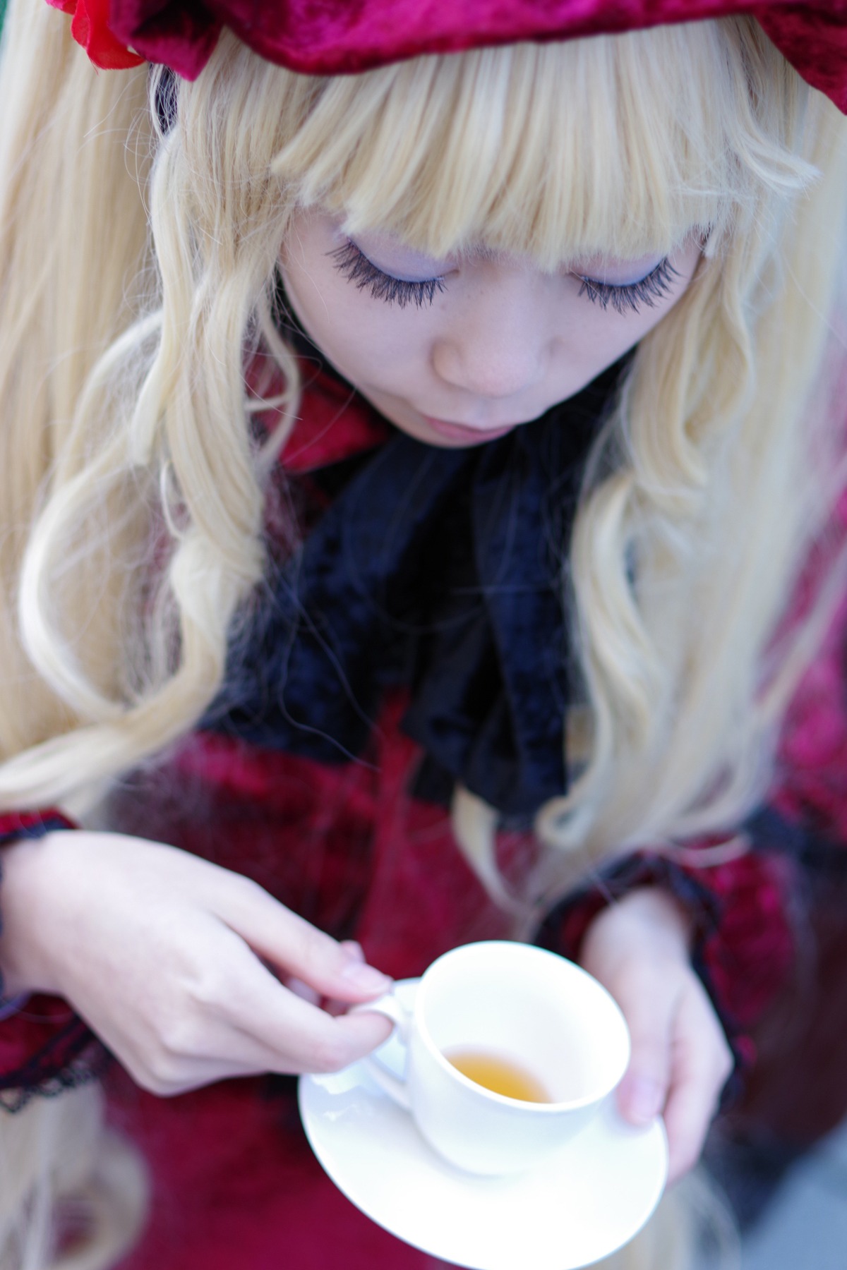 1girl bangs blonde_hair blurry blurry_background blurry_foreground cup depth_of_field flower long_hair saucer shinku smile solo spoon tea teacup