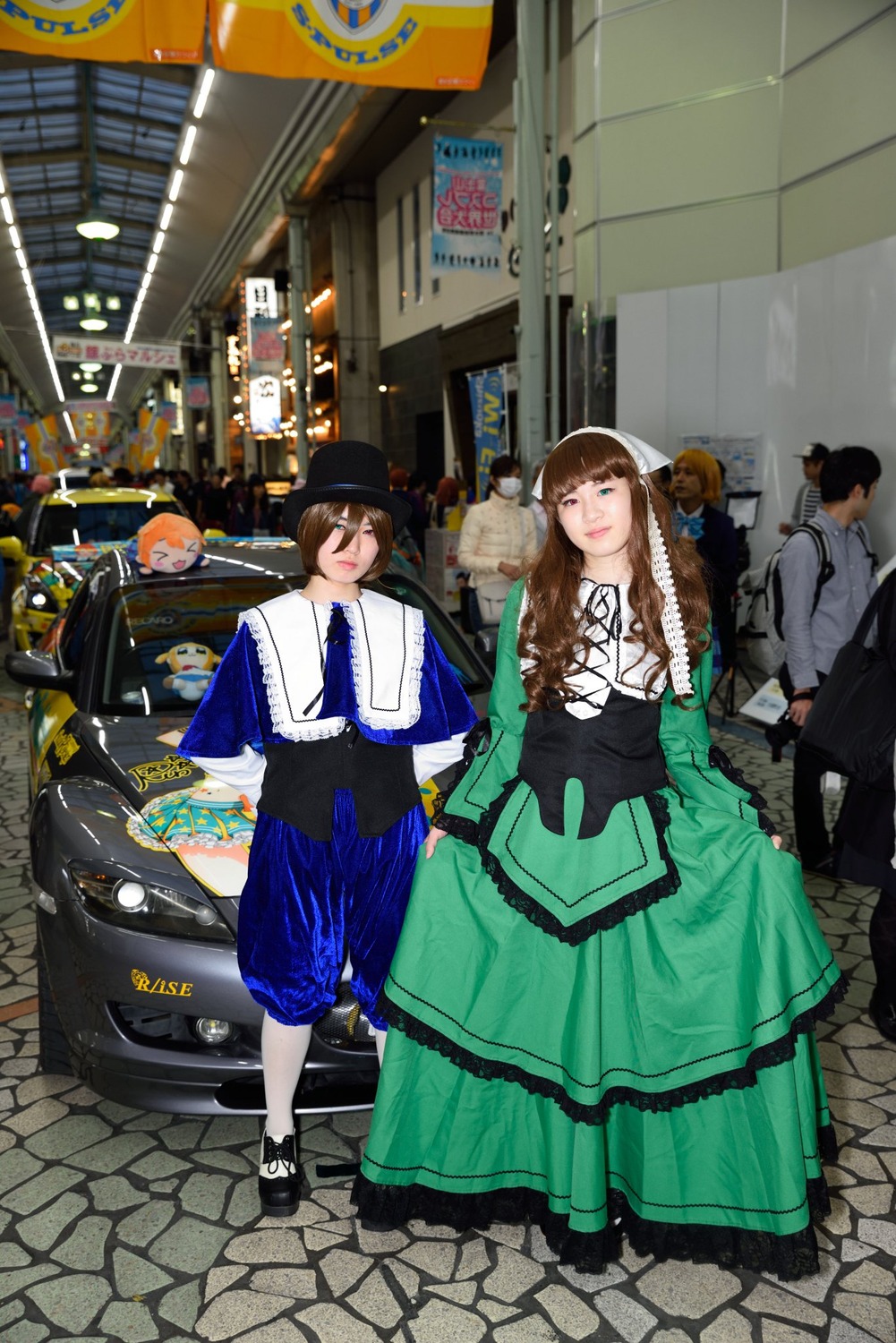brown_hair dress ground_vehicle hat long_hair motor_vehicle multiple_boys multiple_cosplay multiple_girls outdoors road shoes sign smile standing tagme