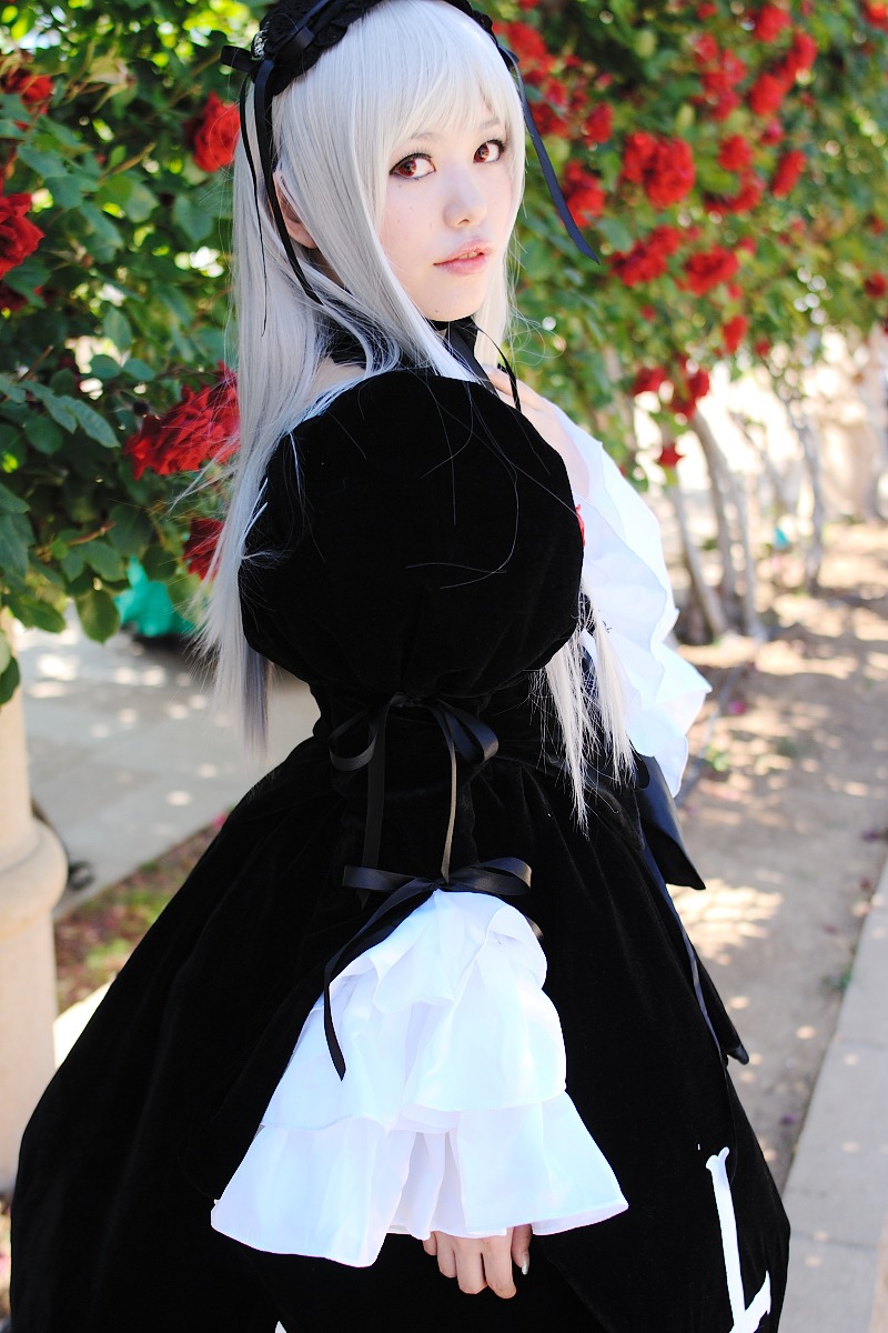 1girl bangs black_dress blurry blurry_background depth_of_field dress flower frills hairband lace lips long_hair long_sleeves looking_at_viewer outdoors red_eyes red_flower solo suigintou