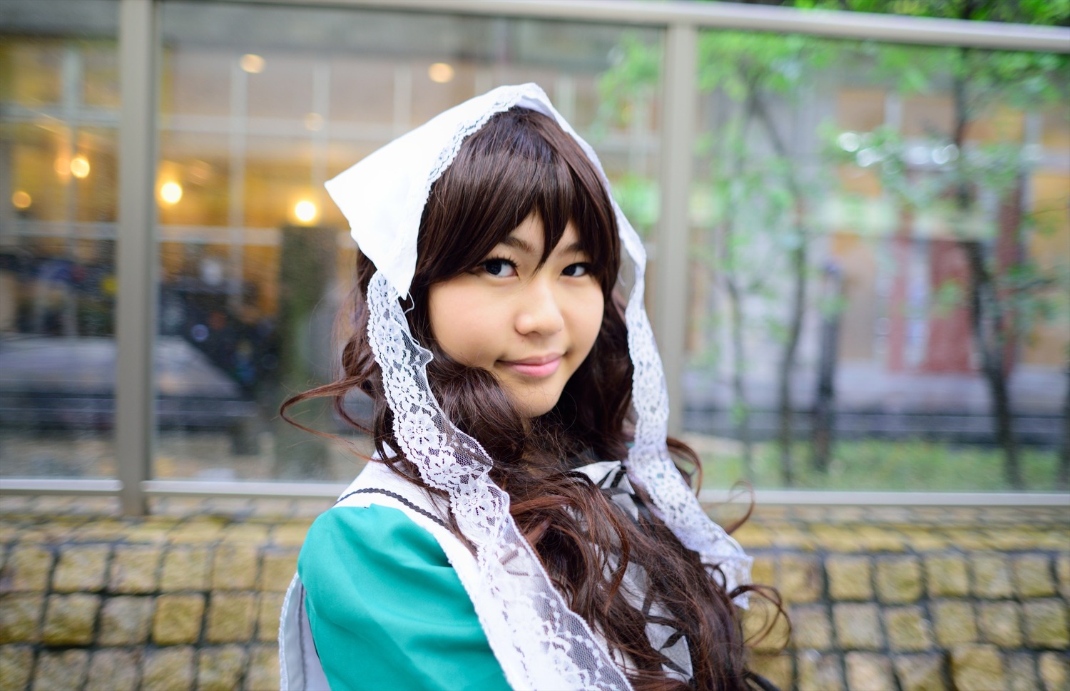 1girl blurry blurry_background brown_hair building depth_of_field fence lips long_hair looking_at_viewer outdoors photorealistic solo suiseiseki upper_body