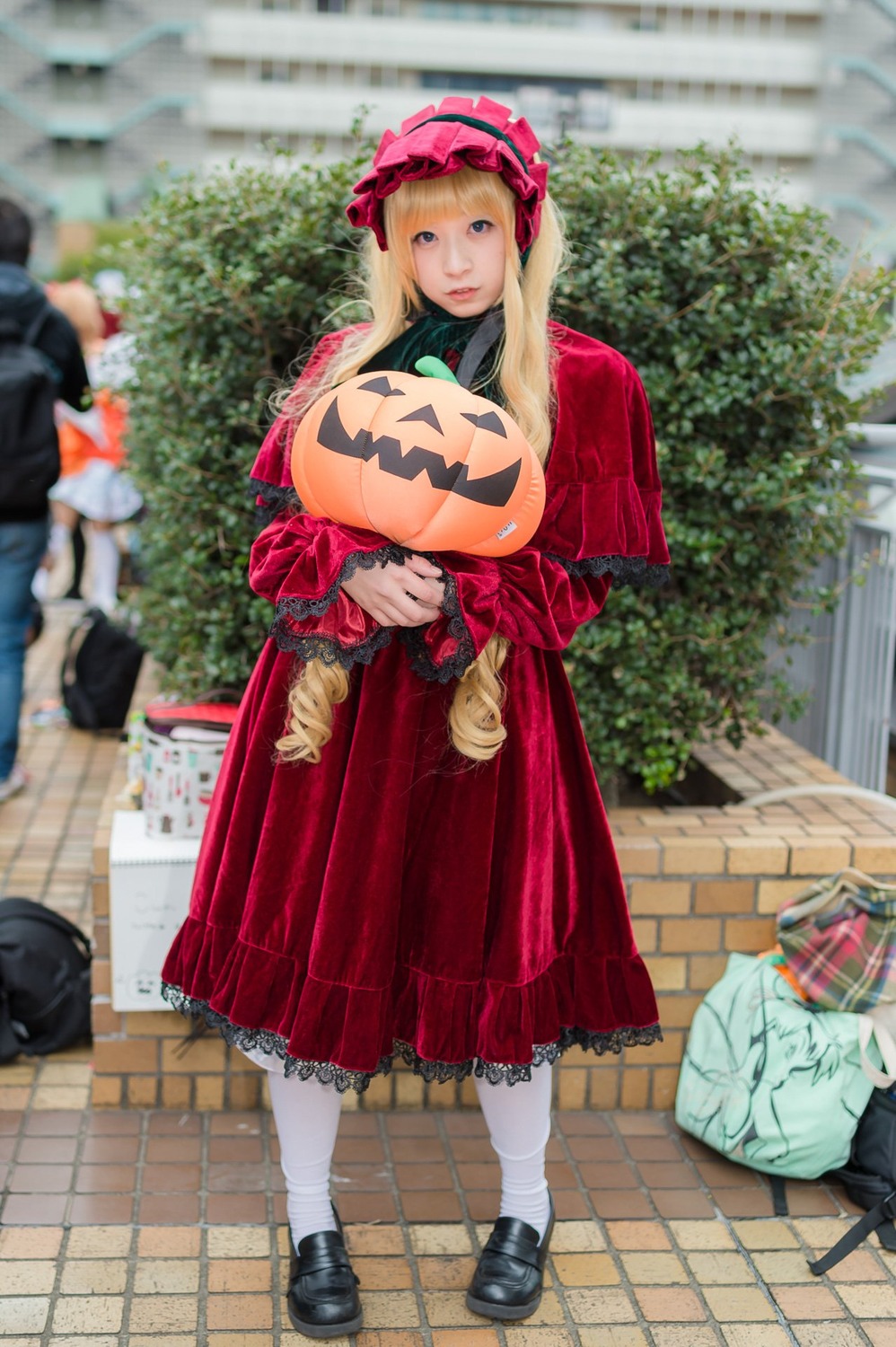 1girl blonde_hair blurry bonnet depth_of_field dress frills jack-o'-lantern long_hair long_sleeves looking_at_viewer outdoors pantyhose pavement photo red_dress shinku shoes solo solo_focus standing white_legwear