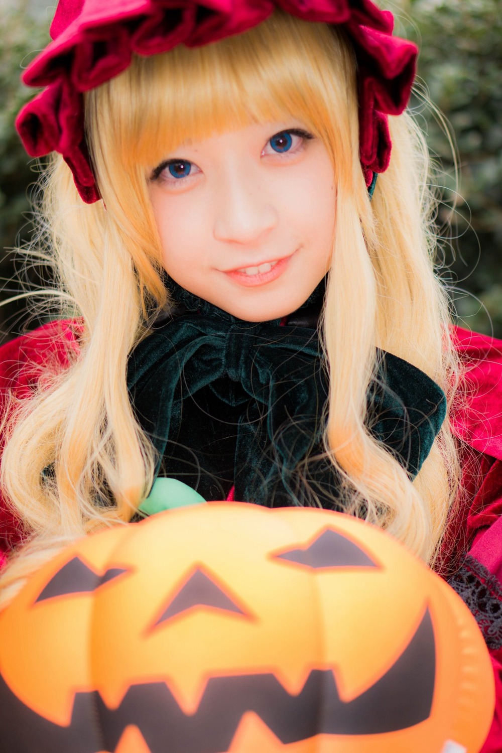 1girl bangs blonde_hair blue_eyes blurry bow depth_of_field hat jack-o'-lantern lips long_hair looking_at_viewer makeup pumpkin shinku smile solo upper_body