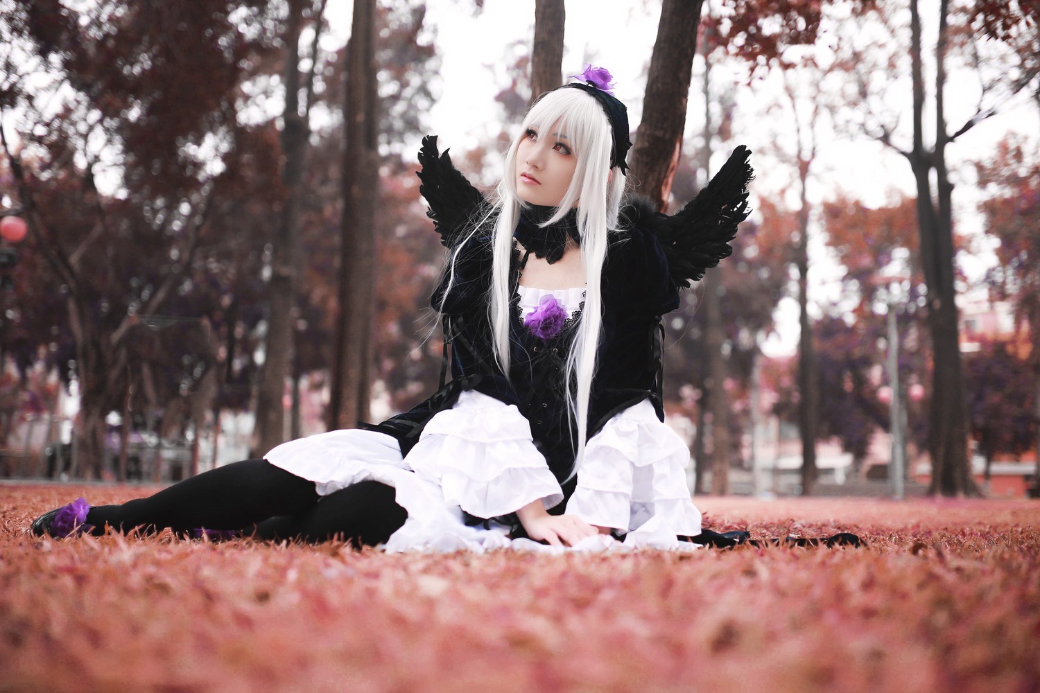 1girl black_wings blurry depth_of_field dress frills gothic_lolita hairband lips long_hair long_sleeves sitting solo suigintou wings