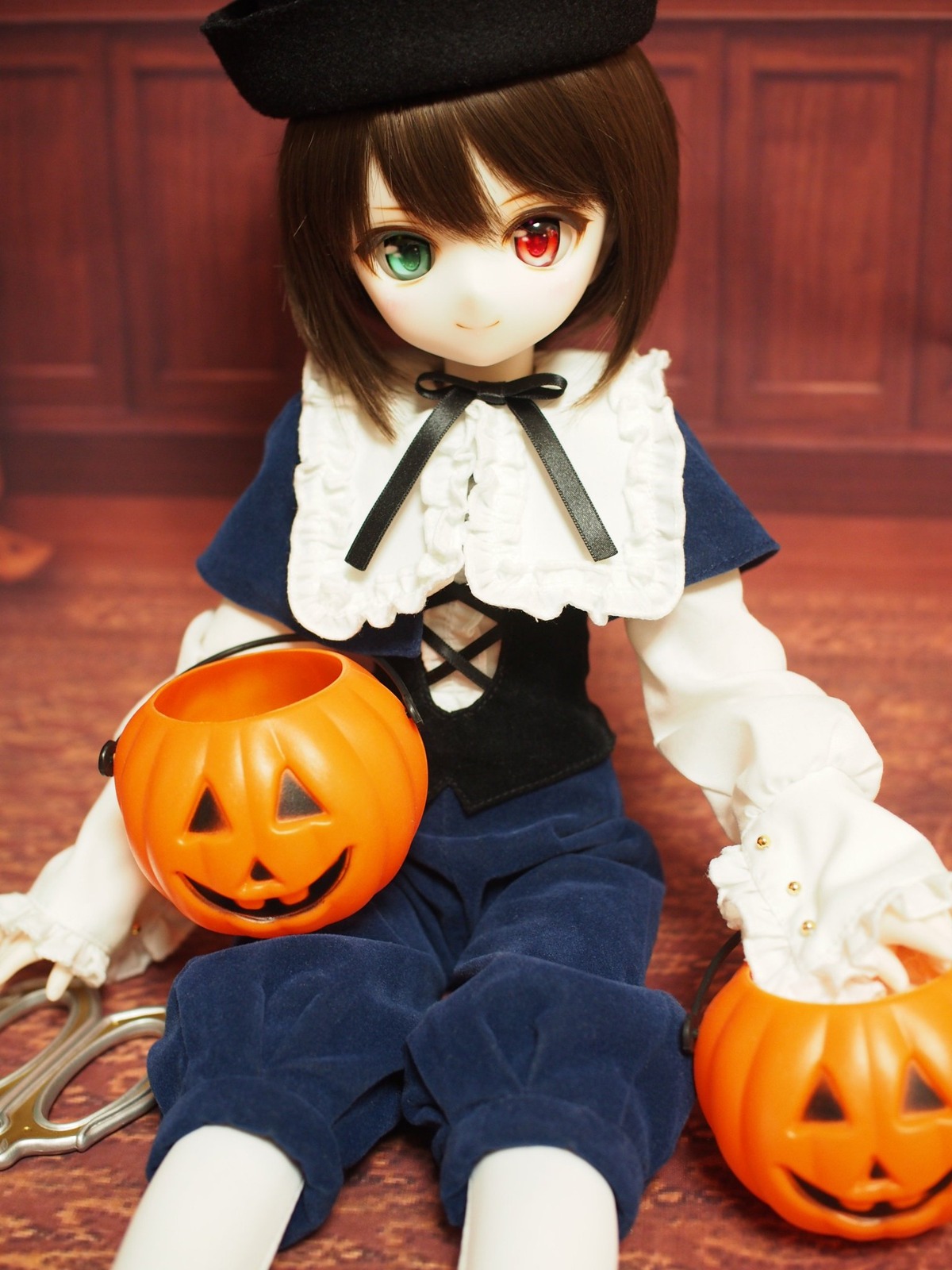 1girl brown_hair capelet doll halloween hat heterochromia jack-o'-lantern long_sleeves looking_at_viewer pantyhose pumpkin red_eyes ribbon short_hair sitting smile solo souseiseki