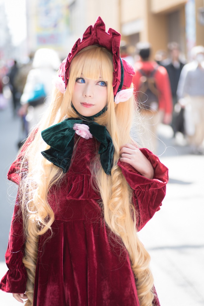 1girl bangs blonde_hair blue_eyes blurry blurry_background blurry_foreground bonnet coat depth_of_field dress flower hat lips long_hair looking_at_viewer photo red_dress shinku solo solo_focus standing very_long_hair