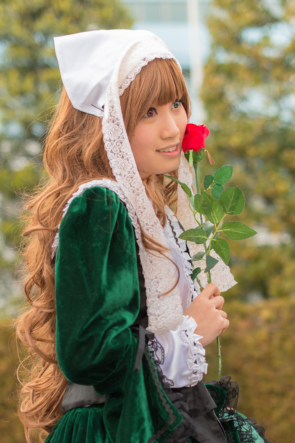 1girl bangs blurry blurry_background brown_eyes brown_hair depth_of_field dress flower green_dress hat lips long_hair long_sleeves looking_at_viewer outdoors smile solo suiseiseki