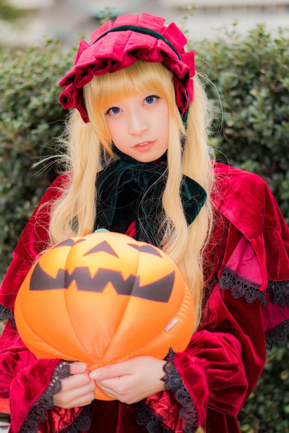 1girl bangs blonde_hair blue_eyes blurry blurry_background depth_of_field hat holding jack-o'-lantern lips long_hair long_sleeves looking_at_viewer pumpkin realistic shinku solo upper_body