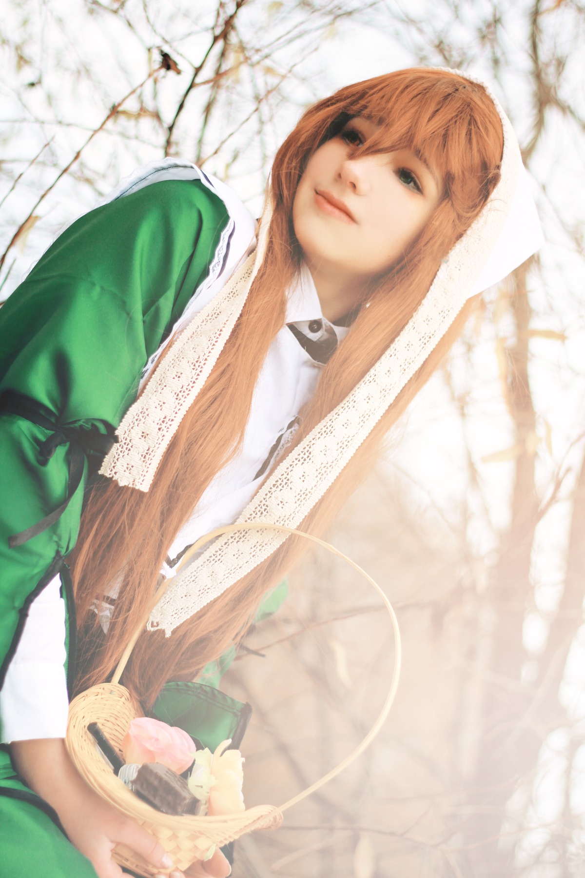 1girl bangs bare_tree blonde_hair blurry blurry_foreground closed_mouth day depth_of_field dress green_dress lips long_hair long_sleeves outdoors solo suiseiseki tree