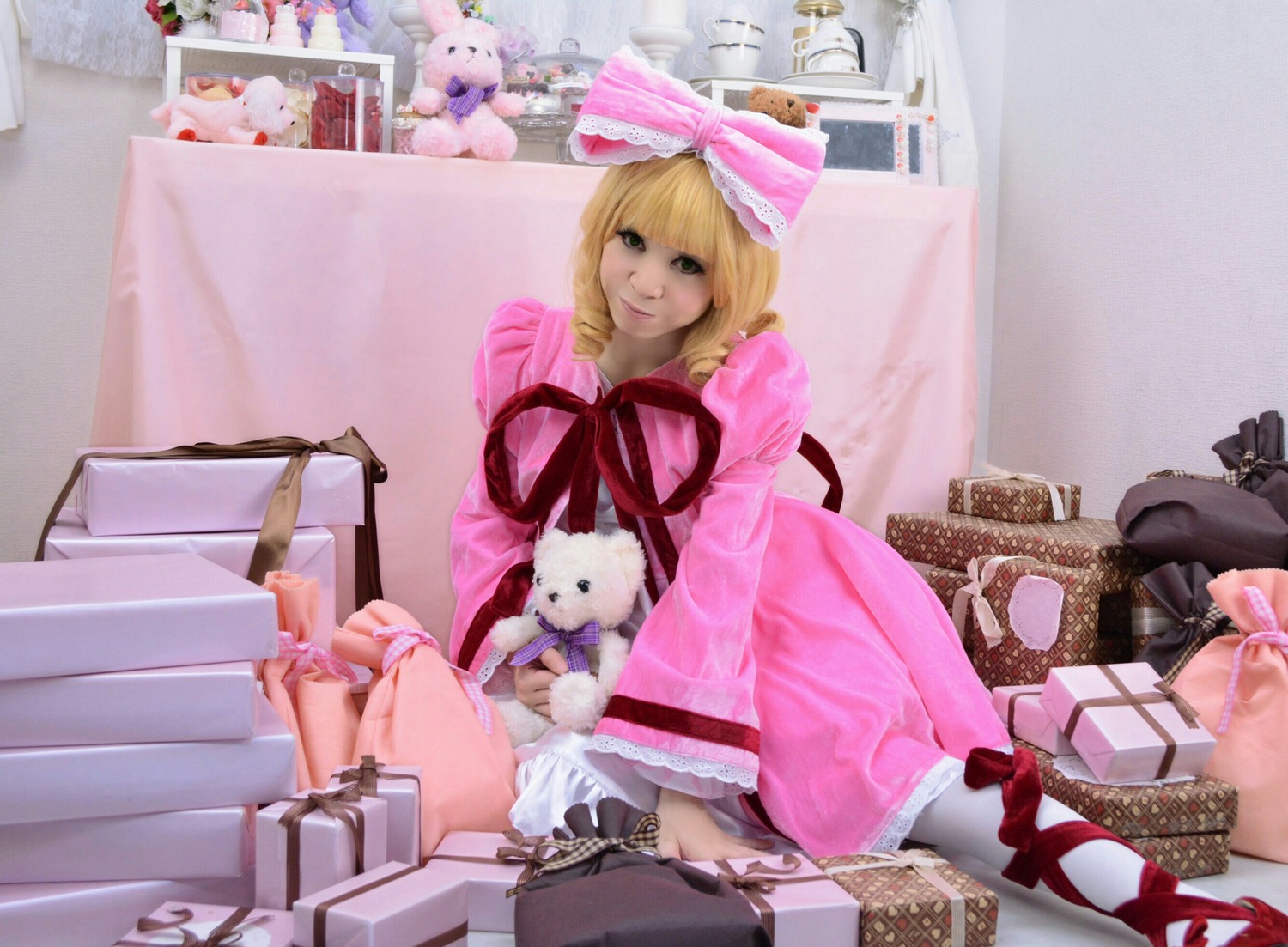 1girl bed bedroom blonde_hair green_eyes hinaichigo pillow pink_dress ribbon sitting solo stuffed_animal teddy_bear