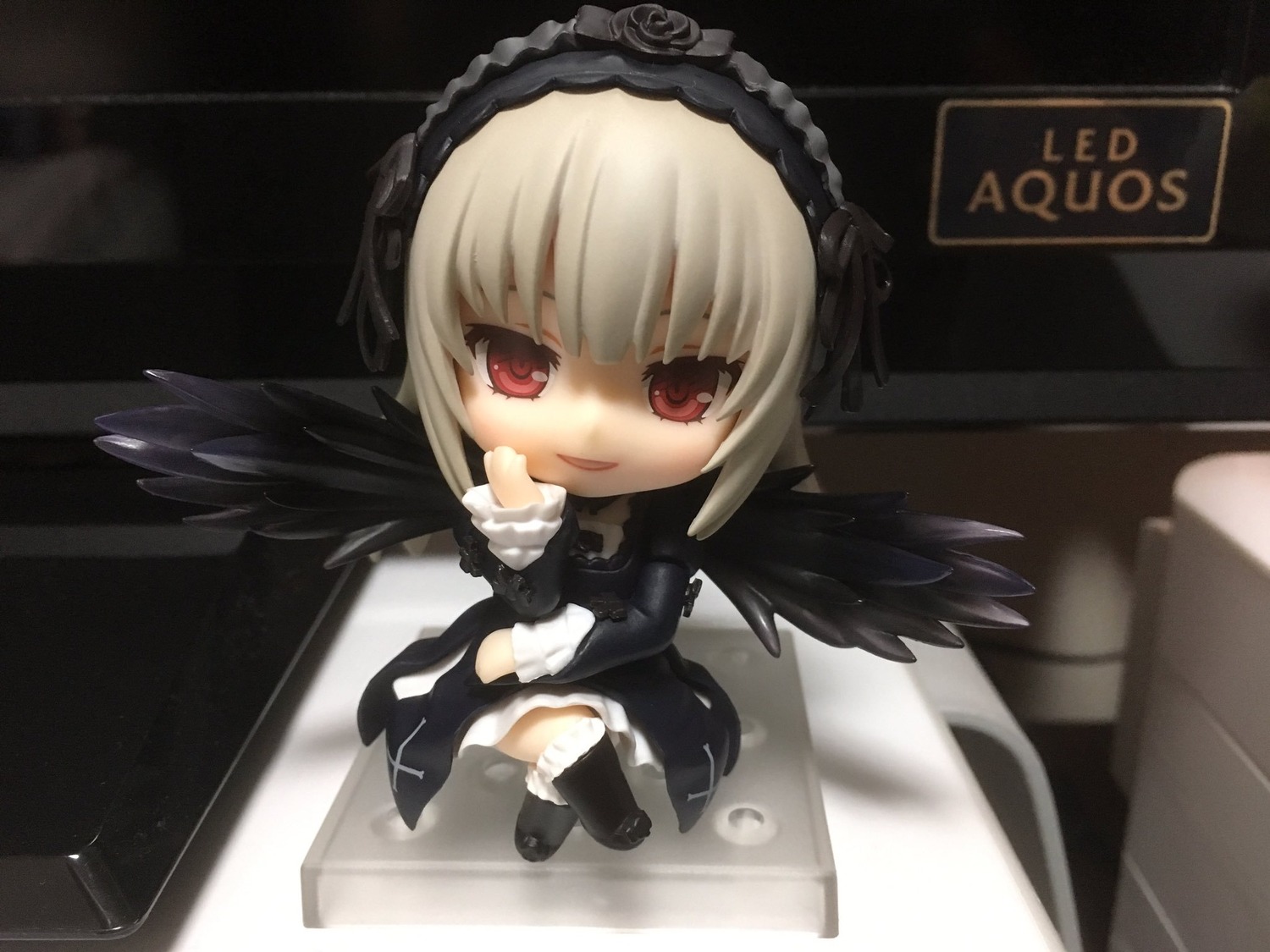 1girl black_legwear black_wings blonde_hair chibi doll dress hairband long_sleeves looking_at_viewer red_eyes smile solo standing suigintou thighhighs wings