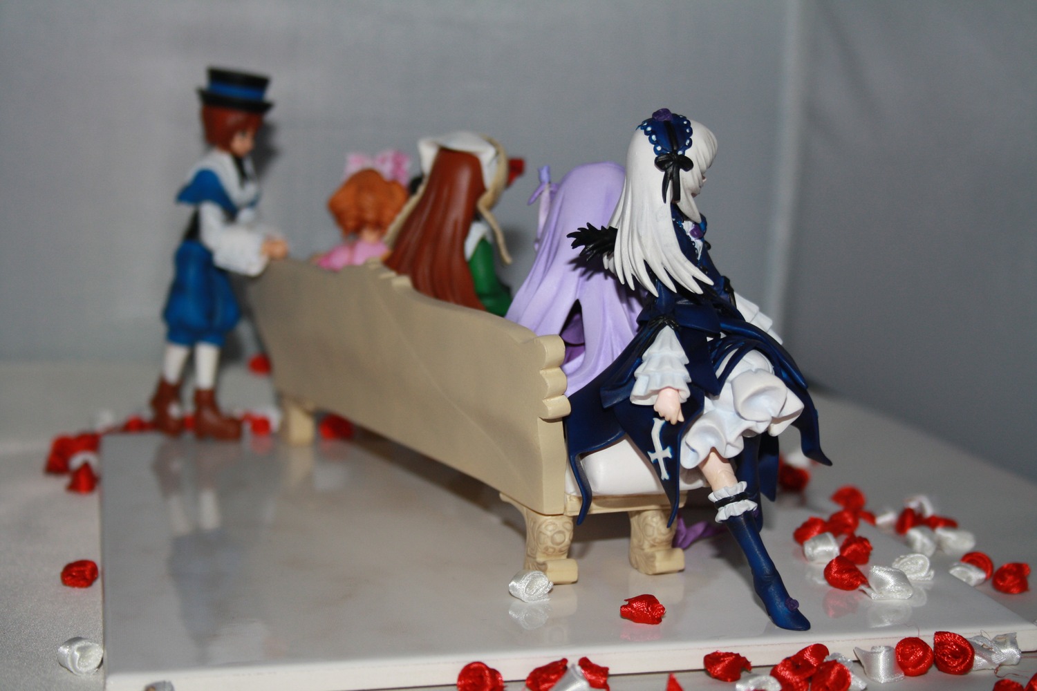 1boy 4girls blonde_hair blue_flower blurry blurry_foreground boots depth_of_field doll dress flower hat long_hair long_sleeves motion_blur multiple_dolls multiple_girls photo red_flower red_rose ribbon rose tagme very_long_hair