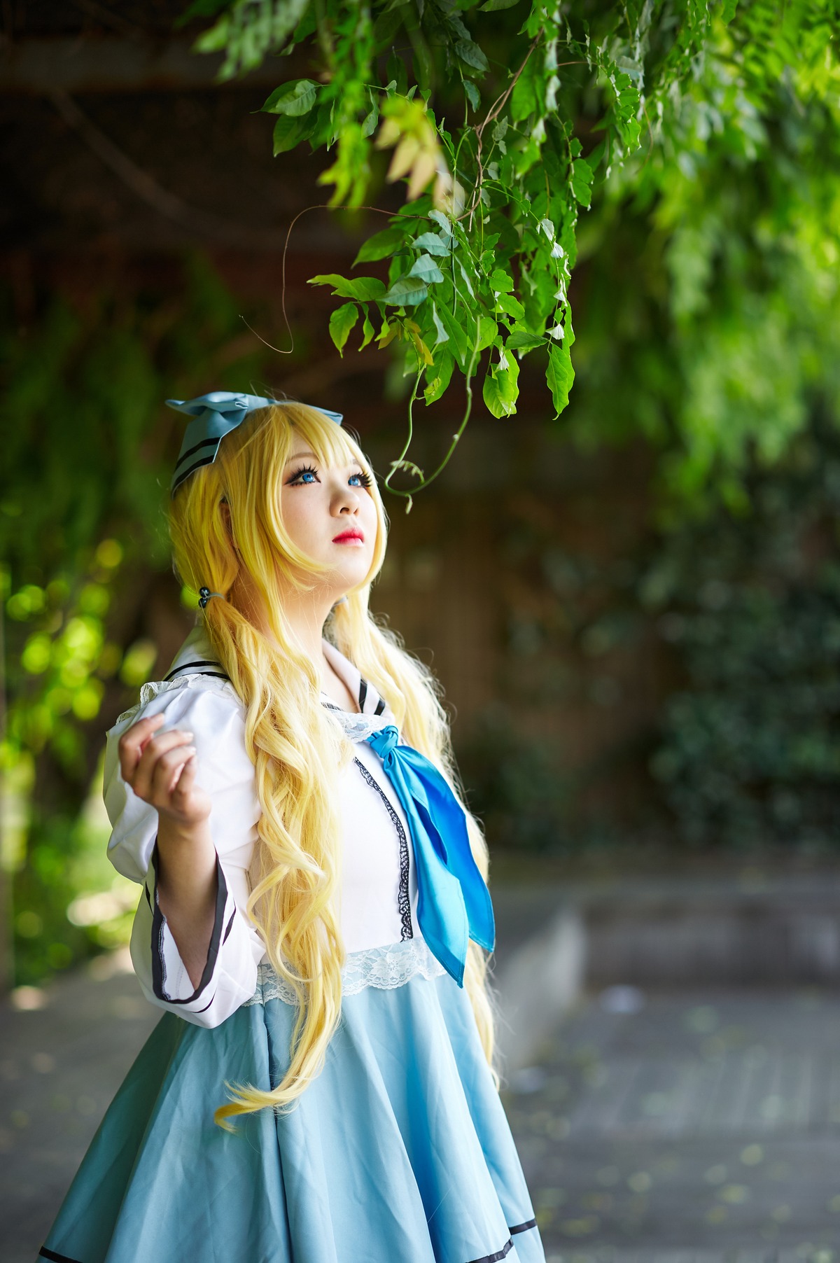 1girl blonde_hair blue_eyes blurry blurry_background bug butterfly_hair_ornament depth_of_field dress hair_ribbon lips long_hair nose outdoors realistic ribbon shinku skirt solo