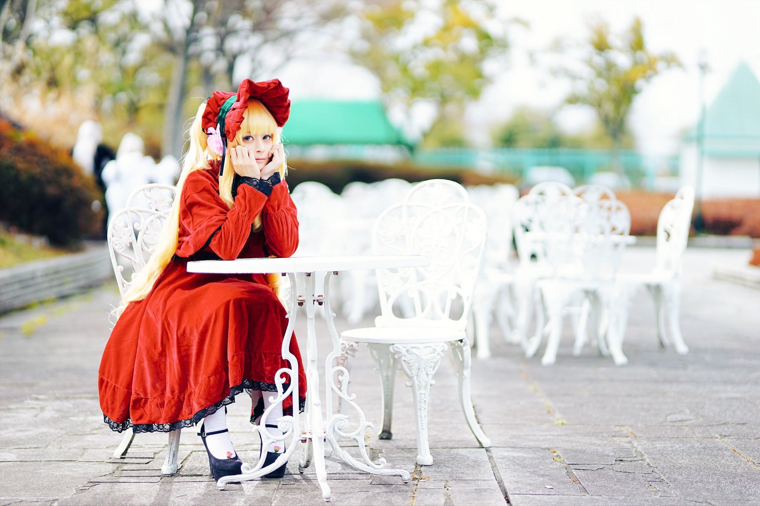 1girl blonde_hair blue_eyes blurry blurry_background blurry_foreground depth_of_field dress flower long_sleeves photo photo_background red_dress shinku sitting solo standing