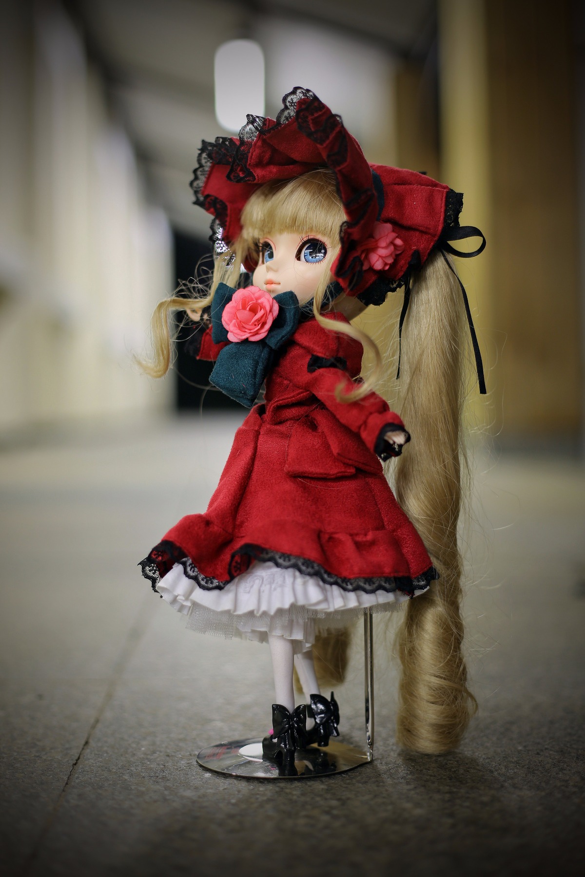 1girl blonde_hair blue_eyes bonnet bow doll dress figure flower frills long_hair long_sleeves looking_at_viewer photo pink_bow pink_rose red_dress rose shinku solo standing twintails