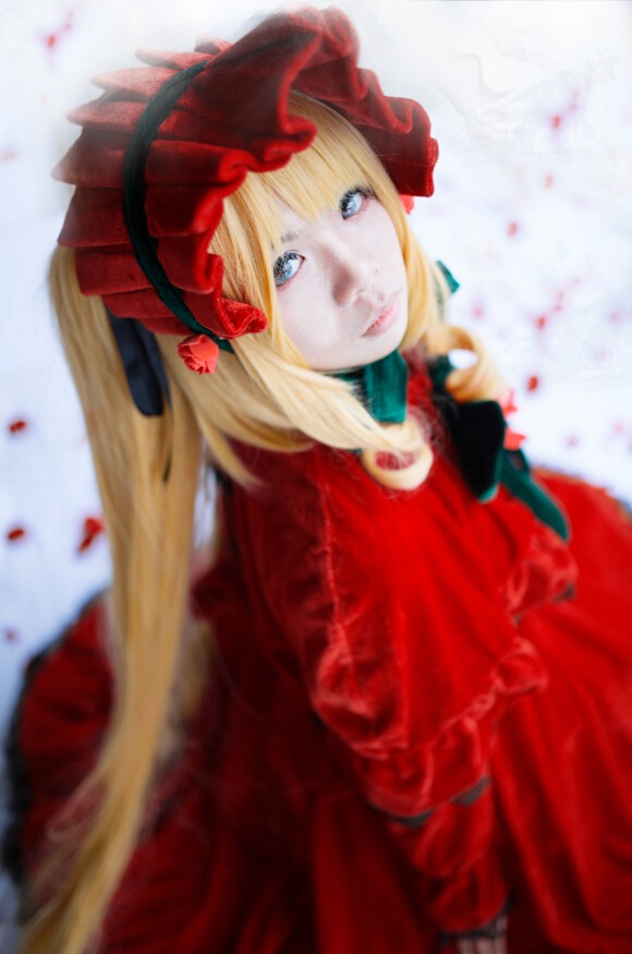 1girl blonde_hair blue_eyes blurry blurry_background blurry_foreground bonnet depth_of_field dress flower long_hair looking_at_viewer motion_blur red_dress rose shinku solo