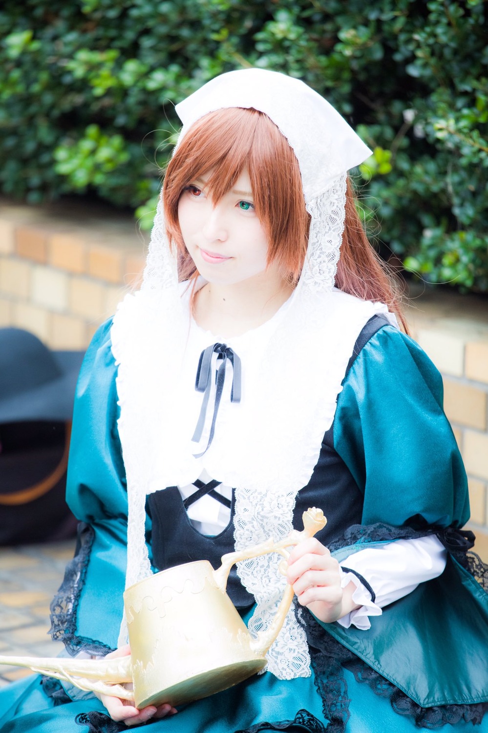 1girl 3d blue_dress blurry blurry_background blurry_foreground brown_hair depth_of_field dress green_eyes head_scarf heterochromia holding long_hair long_sleeves looking_at_viewer photo smile solo suiseiseki