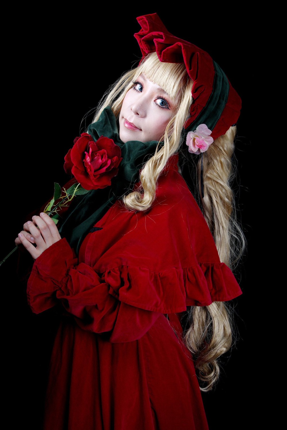 1girl bangs blonde_hair blue_eyes dress flower holding holding_flower lips long_hair long_sleeves looking_at_viewer red_capelet red_dress red_flower red_rose rose shinku solo