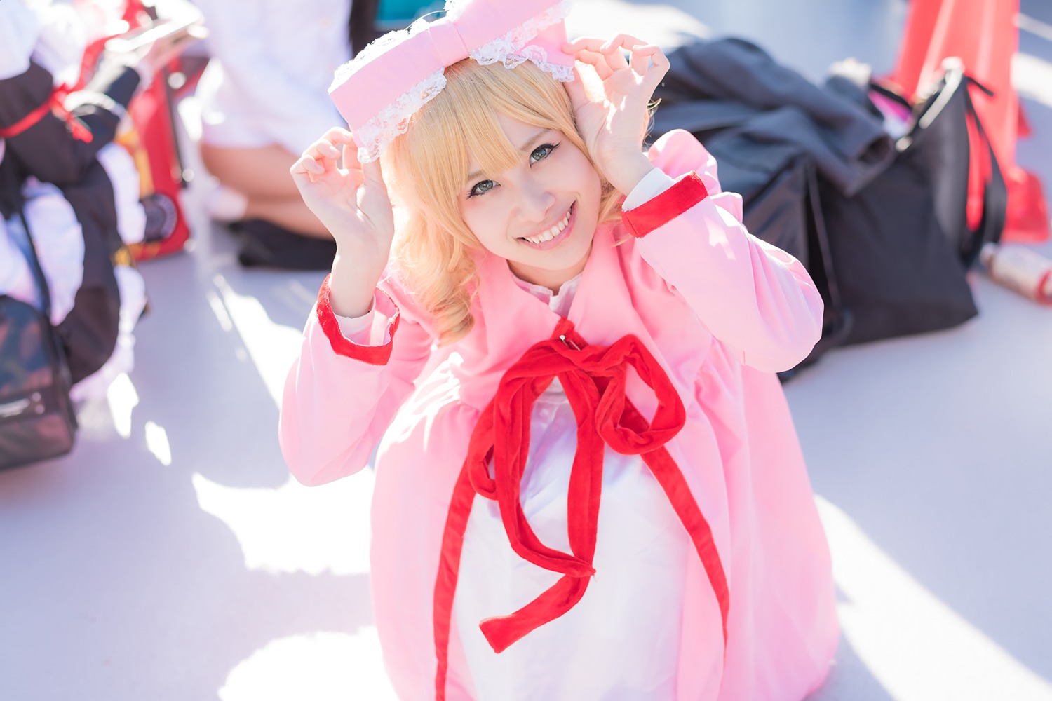 blonde_hair blurry blurry_background blurry_foreground capelet depth_of_field dress hinaichigo long_sleeves looking_at_viewer motion_blur photo ribbon short_hair smile solo teeth