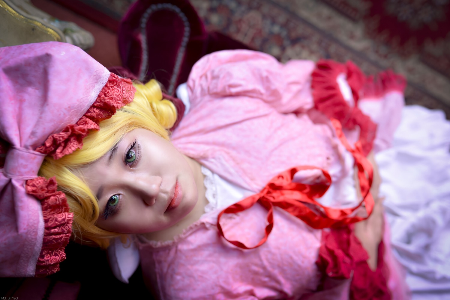 1girl blonde_hair blurry blurry_foreground depth_of_field dress flower frills green_eyes hat hinaichigo lips looking_at_viewer makeup photo realistic solo umbrella