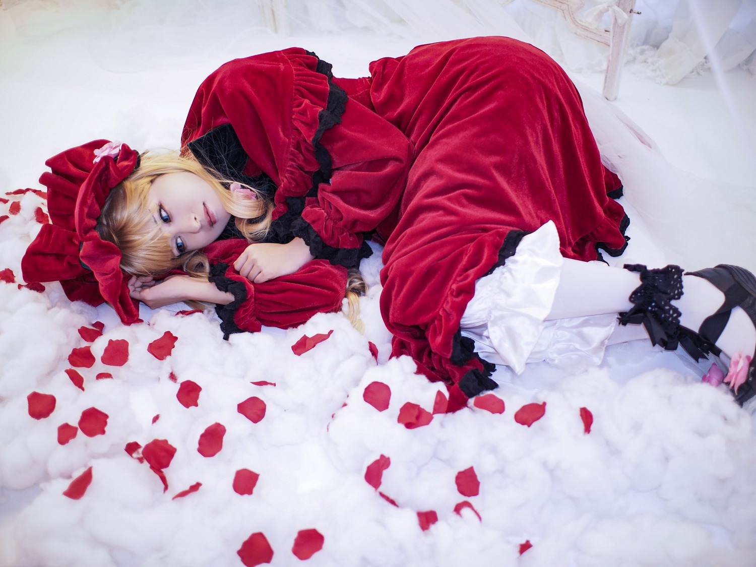 1girl bangs blonde_hair blue_eyes bonnet bow dress flower frills lips long_sleeves looking_at_viewer lying on_side petals red_dress rose_petals shinku solo