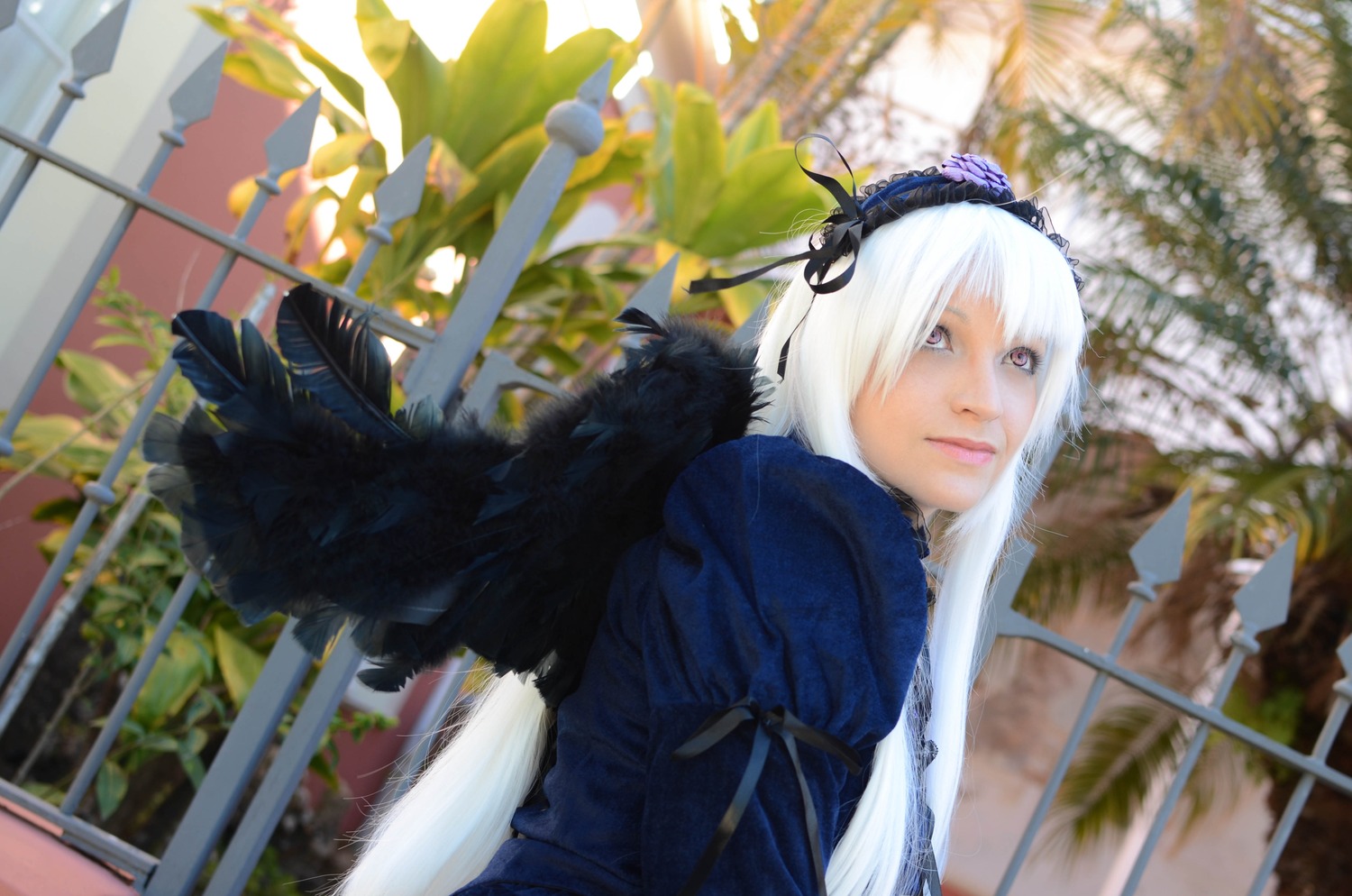 1girl 3d blurry blurry_background building closed_mouth depth_of_field dress feathers frills hairband juliet_sleeves lips long_sleeves looking_at_viewer outdoors plant puffy_sleeves solo suigintou tree white_hair wings