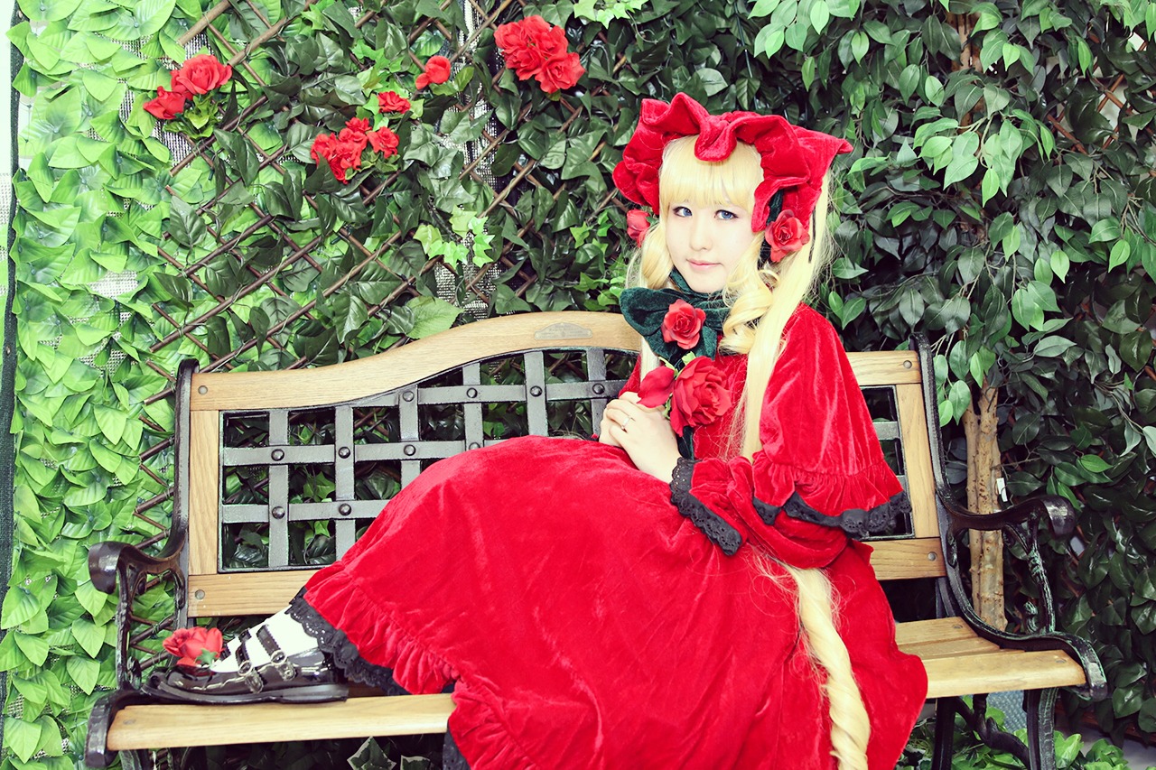 1girl blonde_hair blue_eyes bonnet capelet dress flower long_hair plant railing red_capelet red_dress red_flower red_rose rose shinku sitting solo