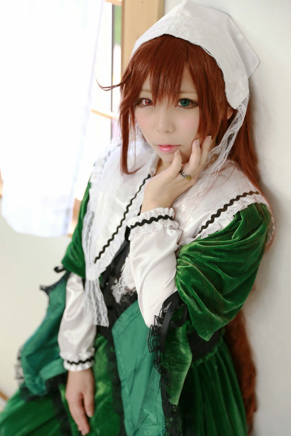 1girl blurry blurry_background blurry_foreground brown_hair depth_of_field dress frills green_dress green_eyes head_scarf heterochromia lips long_hair long_sleeves looking_at_viewer red_eyes solo suiseiseki