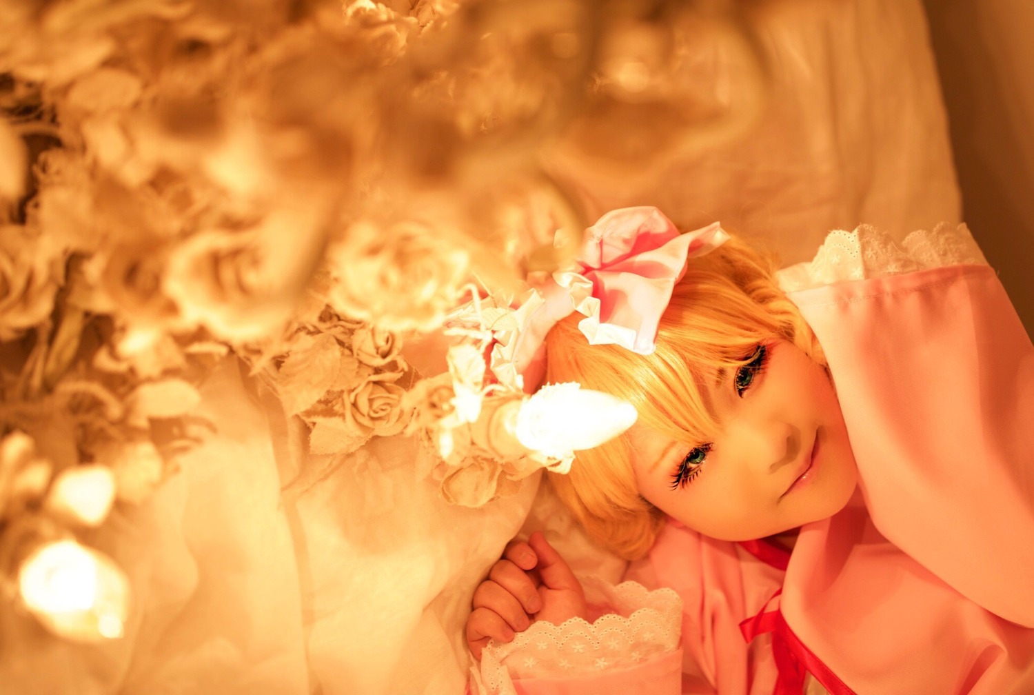 1girl blonde_hair blurry bow depth_of_field dress flower gloves hair_bow hinaichigo lips long_hair looking_at_viewer lying on_side realistic smile solo