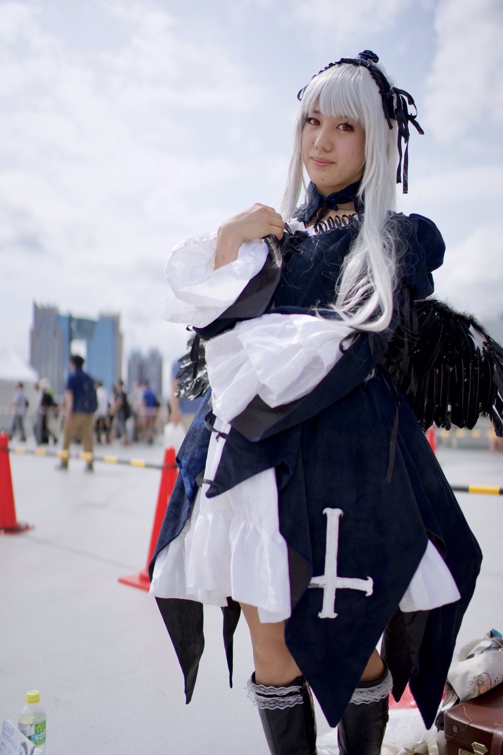 1girl 3d blurry blurry_background boots closed_mouth depth_of_field dress feathers hairband long_hair long_sleeves photo red_eyes solo suigintou