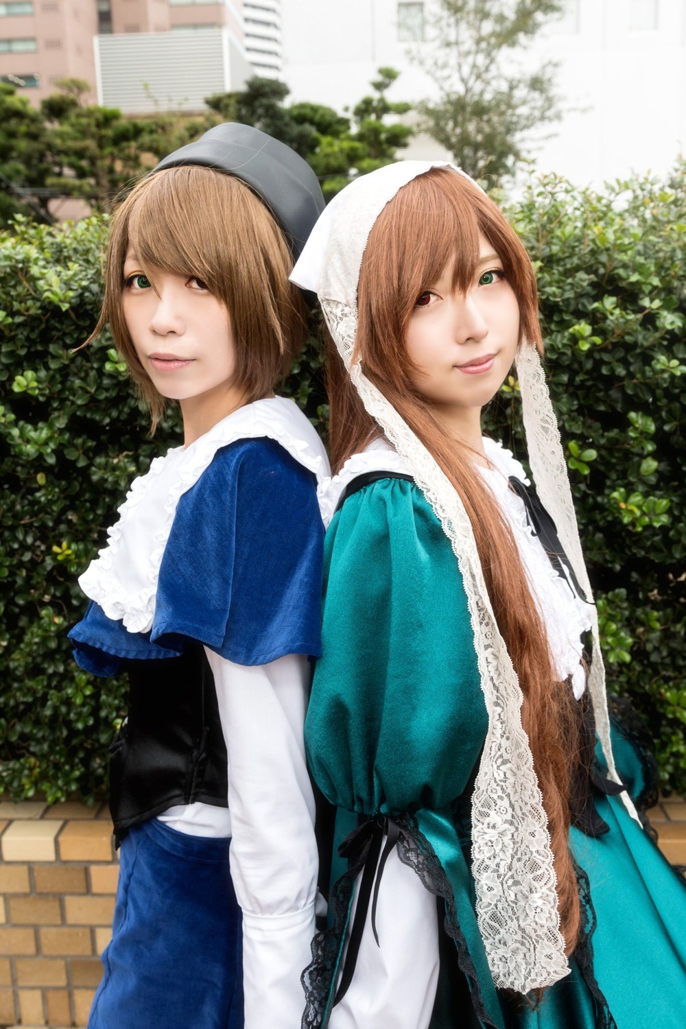 2girls apron blue_dress blurry brown_hair building depth_of_field dress green_eyes hat head_scarf heterochromia lips long_hair looking_at_viewer multiple_cosplay multiple_girls outdoors photo short_hair siblings sisters smile souseiseki suiseiseki swept_bangs tagme twins