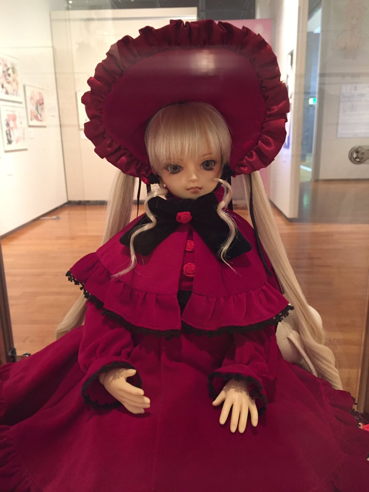 1girl blonde_hair bonnet capelet doll dress expressionless frills indoors long_hair long_sleeves looking_at_viewer shinku sitting solo twintails