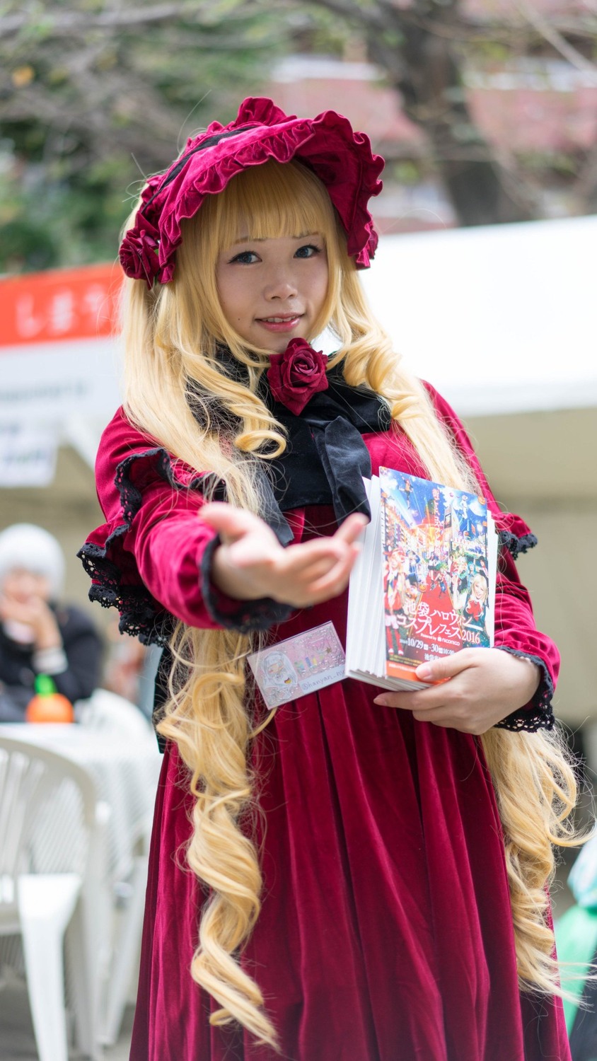 1girl blonde_hair blurry blurry_background blurry_foreground bonnet depth_of_field dress drill_hair flower long_hair looking_at_viewer photo red_dress rose shinku solo solo_focus very_long_hair