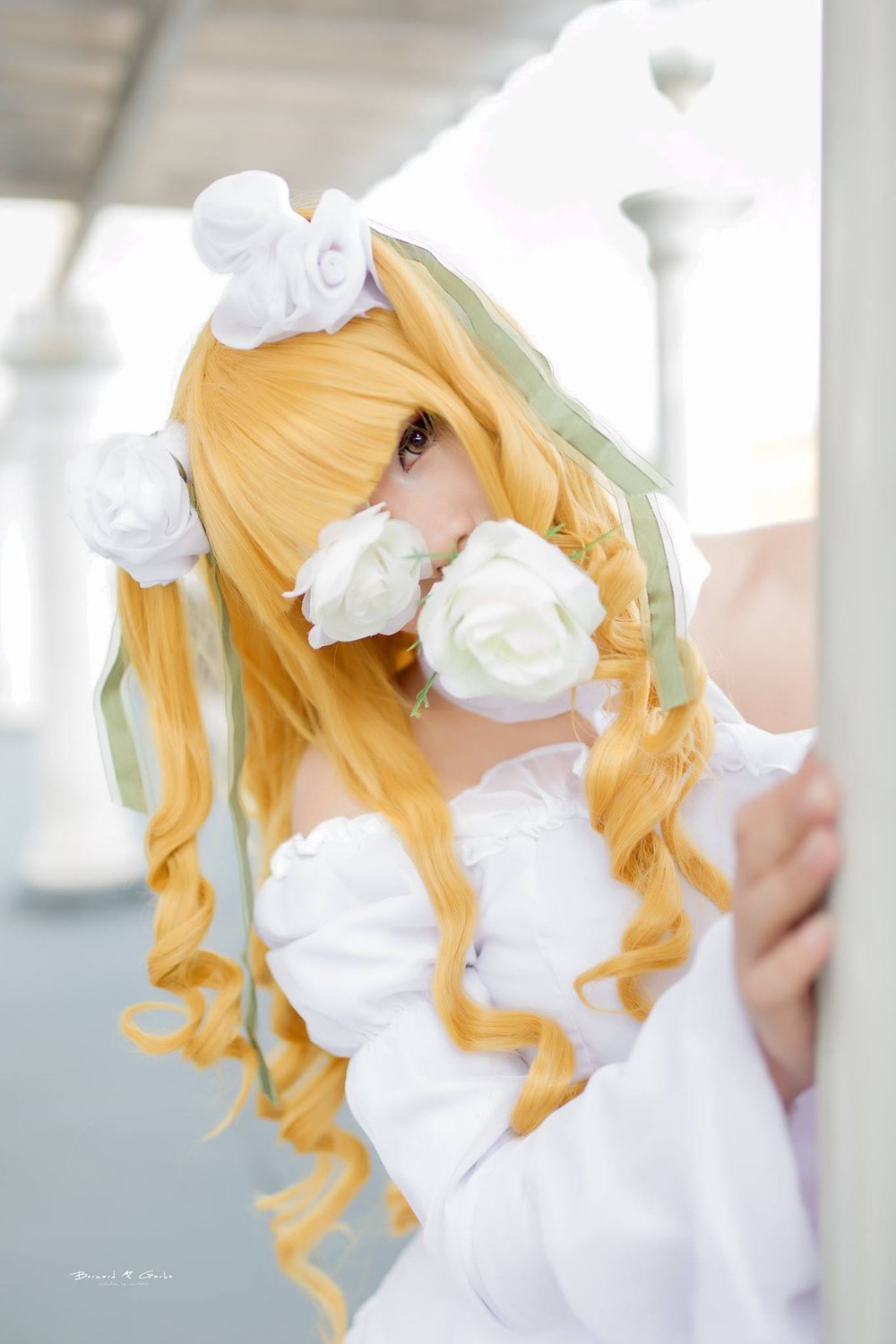 1girl bangs blonde_hair blurry blurry_background blurry_foreground depth_of_field dress flower hair_flower hair_ornament kirakishou long_hair looking_at_viewer photo rose solo white_dress white_flower white_rose