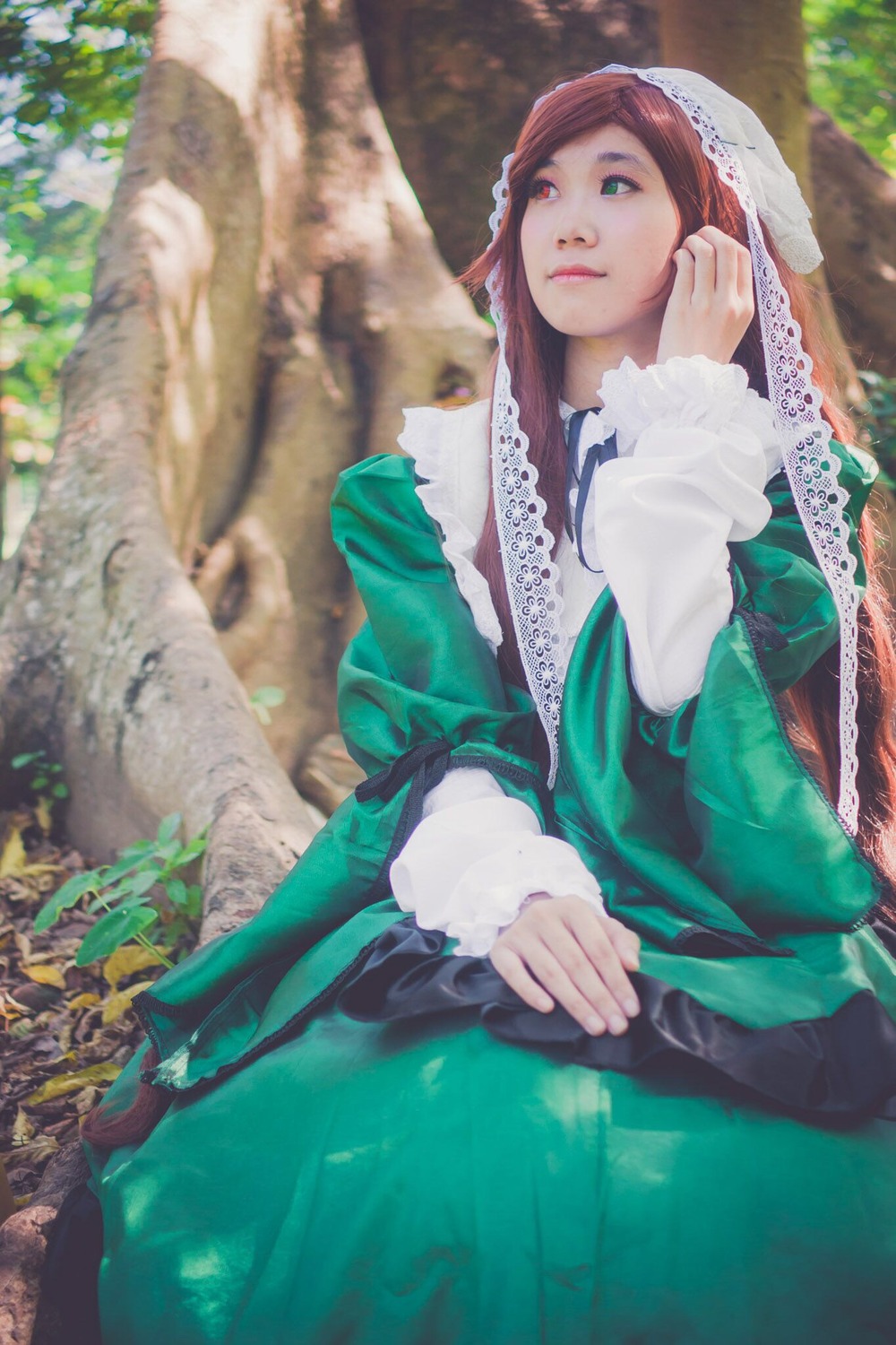 1girl blurry closed_mouth dress green_dress green_eyes lips long_hair long_sleeves monster_girl outdoors pointy_ears sitting solo suiseiseki