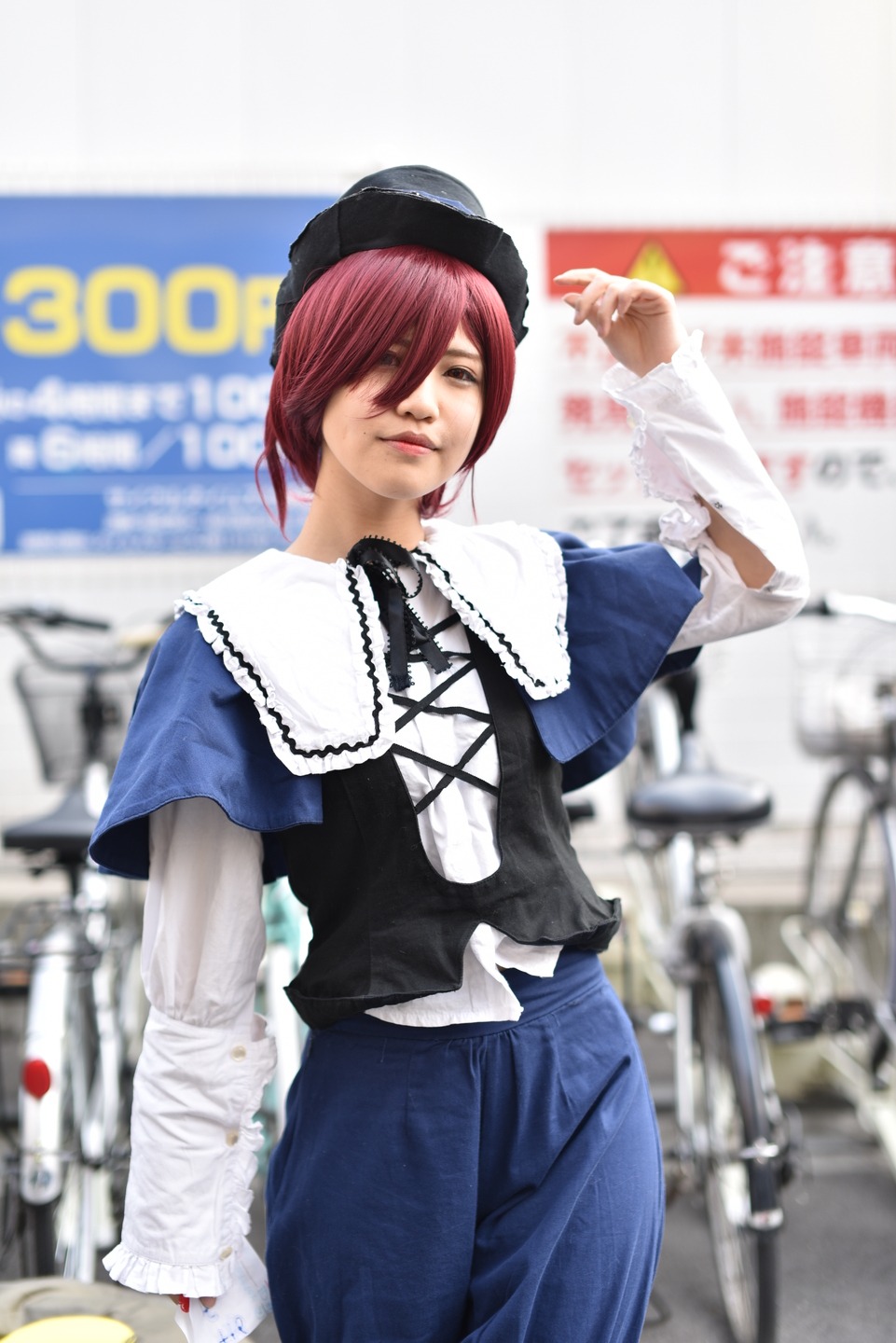 1girl blurry blurry_background blurry_foreground capelet depth_of_field dress hat long_sleeves looking_at_viewer photo red_hair short_hair solo souseiseki standing