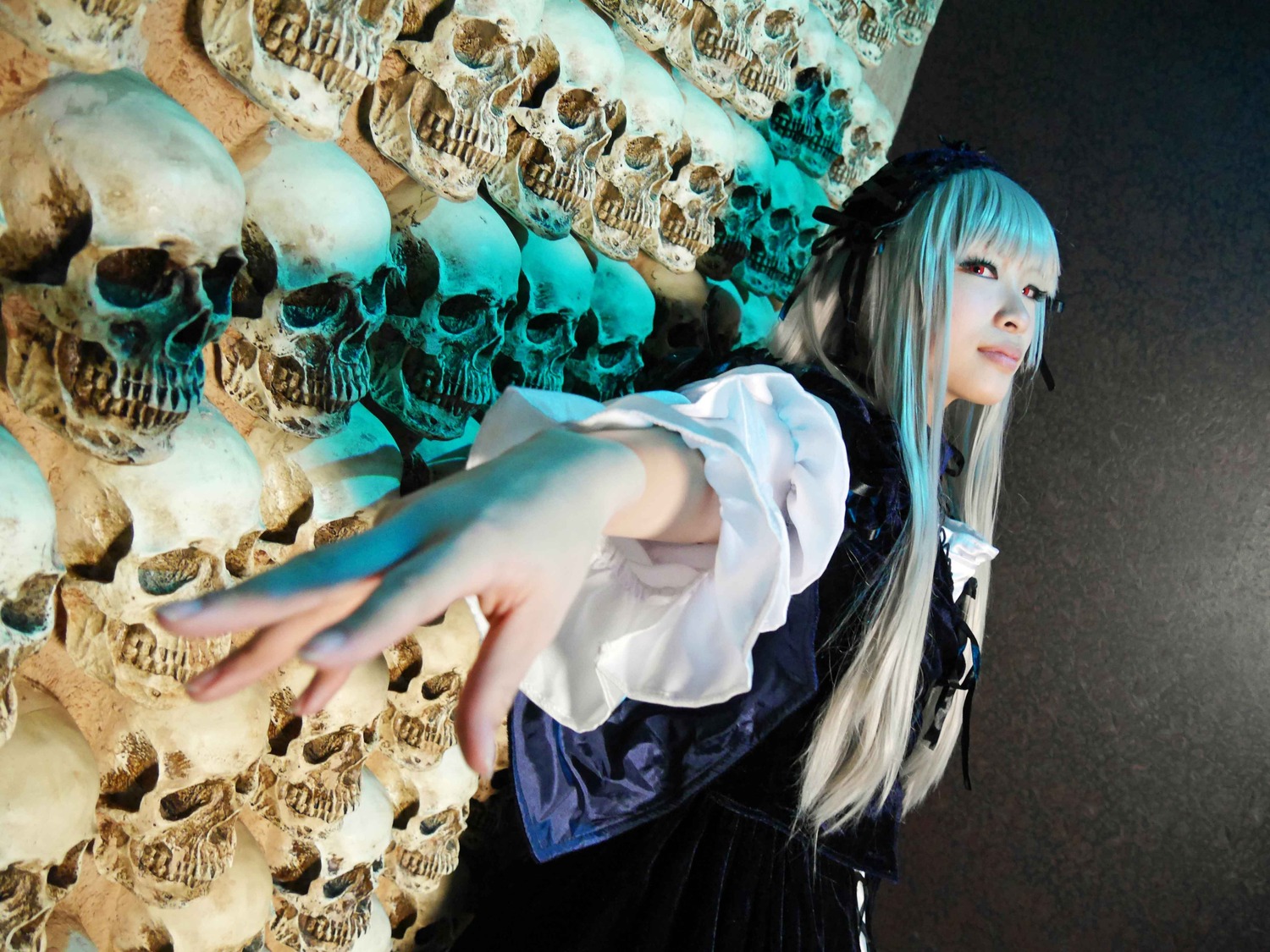 1girl bangs blunt_bangs blurry depth_of_field lips long_hair outstretched_arm red_eyes skirt skull solo suigintou