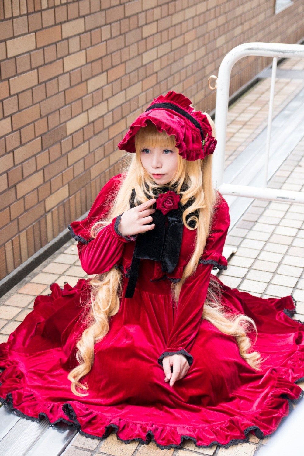 1girl blonde_hair blue_eyes bonnet dress flower frills long_hair long_sleeves photo pink_flower pink_rose red_dress rose shinku sitting solo tile_floor tiles