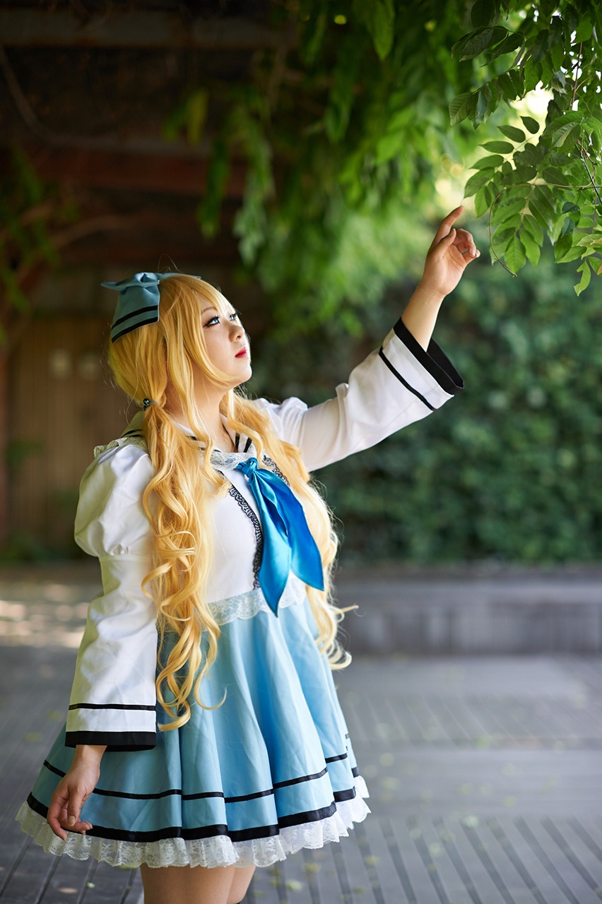 1girl blonde_hair blue_eyes blurry depth_of_field dress lips long_hair looking_up outstretched_arm pointing profile ribbon shinku solo